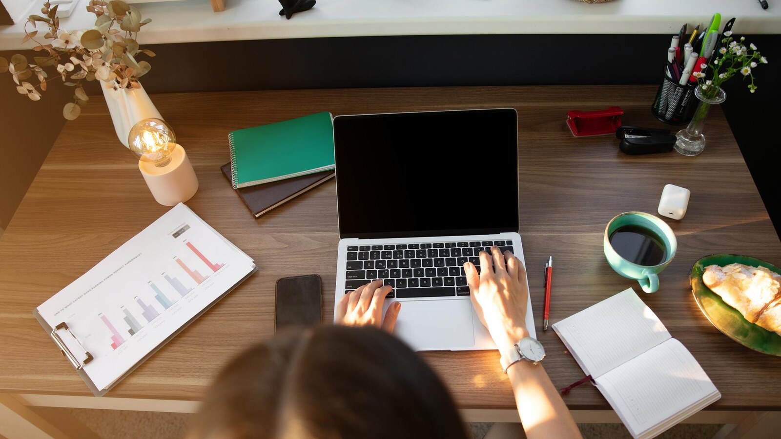 Beginner planning online classes from home with laptop and notebook